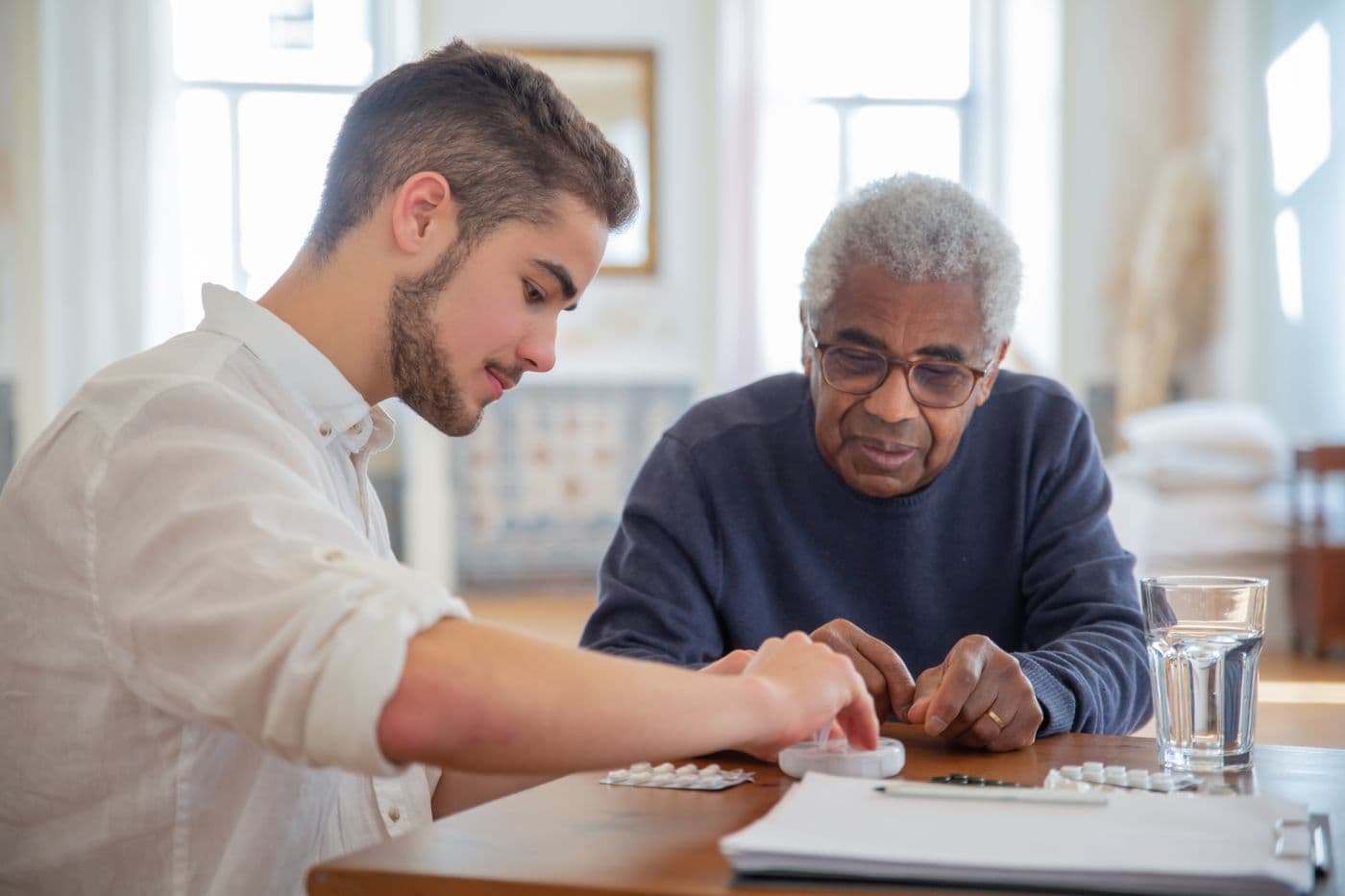 An RN going through a patient's medications with him at home