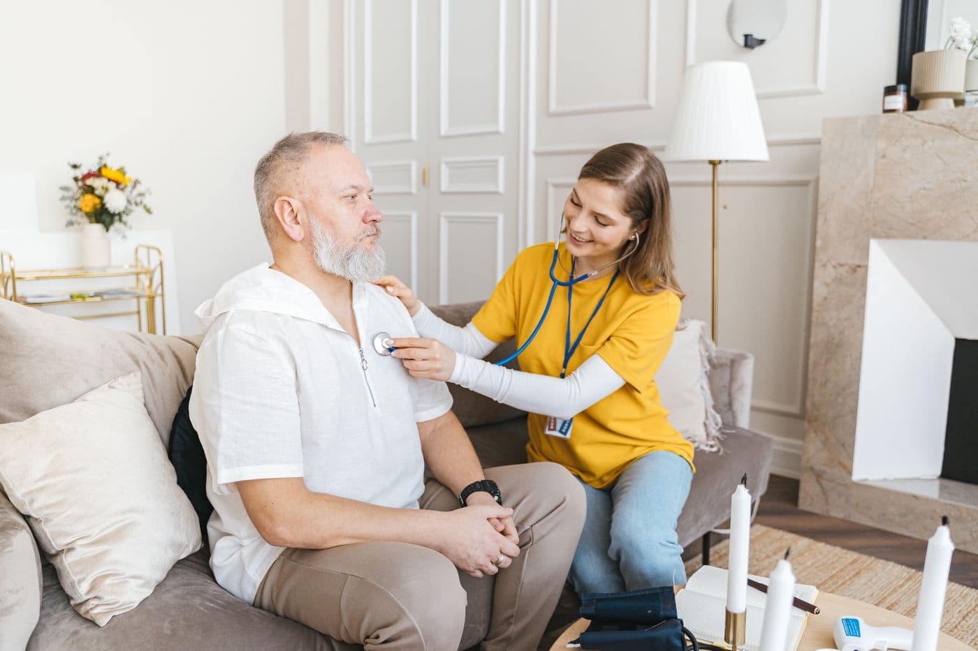 A CareBridge RN listening to a patient's chest during an assessment at home