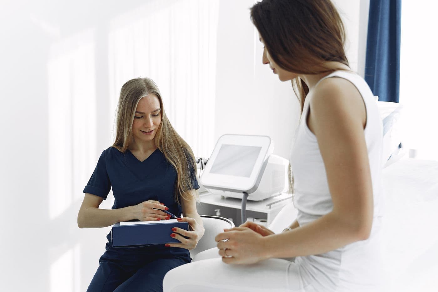 Nurse in scrubs completing a patient assessment